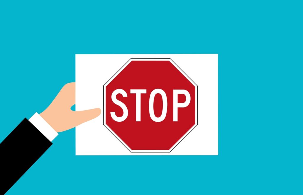 panneau stop tenu par une main