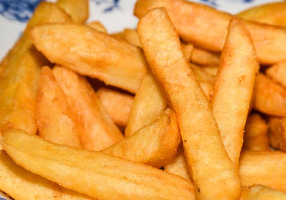 Fresh tasty fried potatoes - appetizing food background. French fries, or simply fries, chips, finger chips, or french-fried potatoes, are batonnet or allumette-cut deep-fried potatoes.