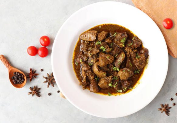 Chicken Liver Masala or Kaleji fry garnished with coriander. Liver fry is a very popular Nonvegetarian Indian dish. Made from the Chicken liver. White background. copy space with spices.