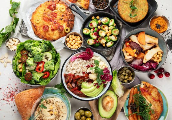Vegetarian and various vegan dishes on grey  table. Healthy food concept with vitamins, fiber and antioxidants. Top view.