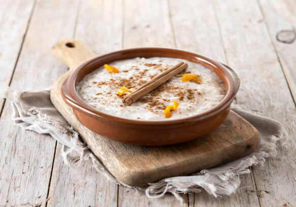 Arroz con leche. Rice pudding with cinnamon in bowl on wooden table
