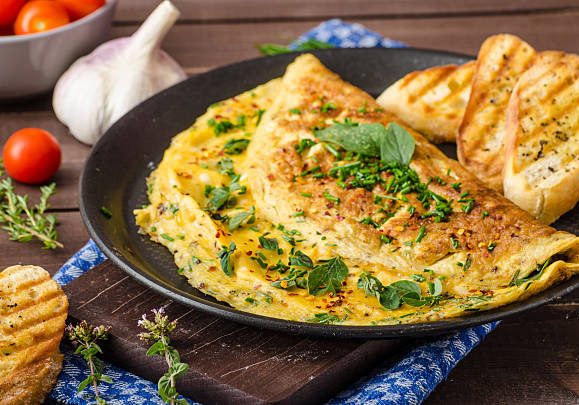 Herb omelette with chives and oregano sprinkled with chili flakes, garlic panini toasts