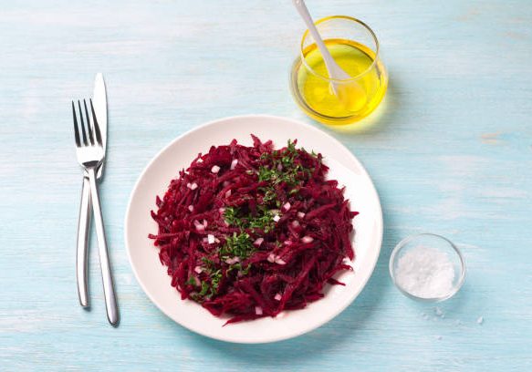 Healthy detox raw beetroot salad with red onion, garlic, herbs and spices on a blue background. diet food. top view
