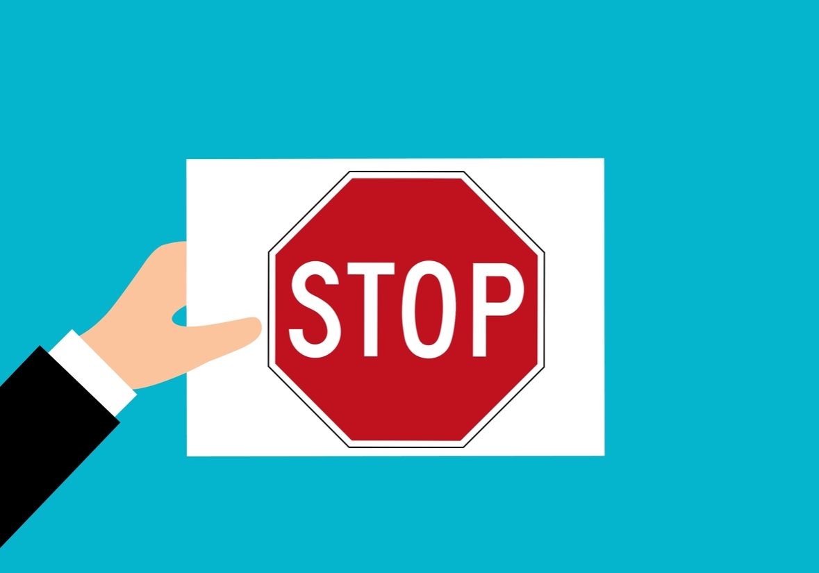 panneau stop tenu par une main